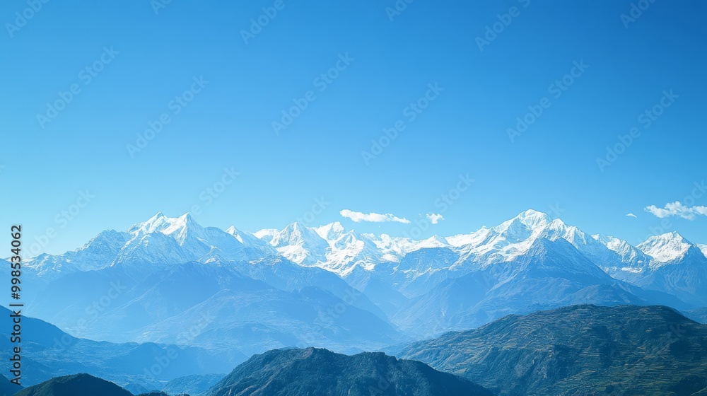 A stunning view of snow-capped mountains against a bright blue sky. A stunning view of snow-capped mountains against a bright blue sky.