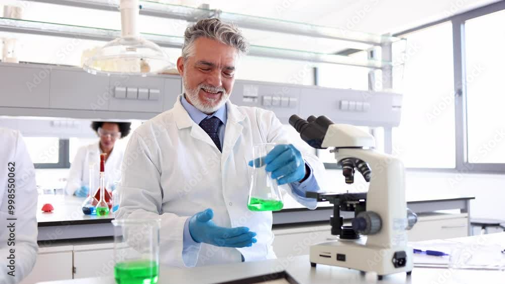 Mature lab specialist examining something on the microscope Mature lab specialist examining something on the microscope
