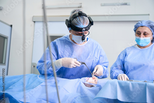 Surgeon performs a polypotomy on a young patient photo