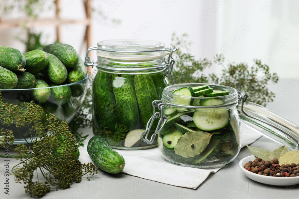 Homemade pickles. Fresh cucumbers in jars and other ingredients on table, closeup Homemade pickles. Fresh cucumbers in jars and other ingredients on table, closeup
