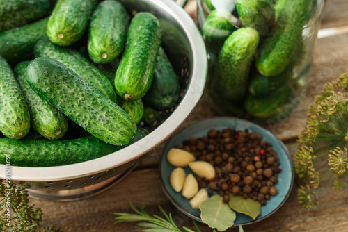 Fresh cucumbers, herbs and spices on wooden table, closeup. Preparation for pickling