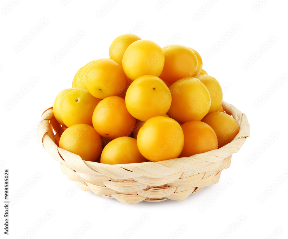 Fresh ripe yellow plums in wicker basket isolated on white Fresh ripe yellow plums in wicker basket isolated on white