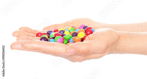 Woman hand holds lot of color candies, isolated on transparent background, fast food concept