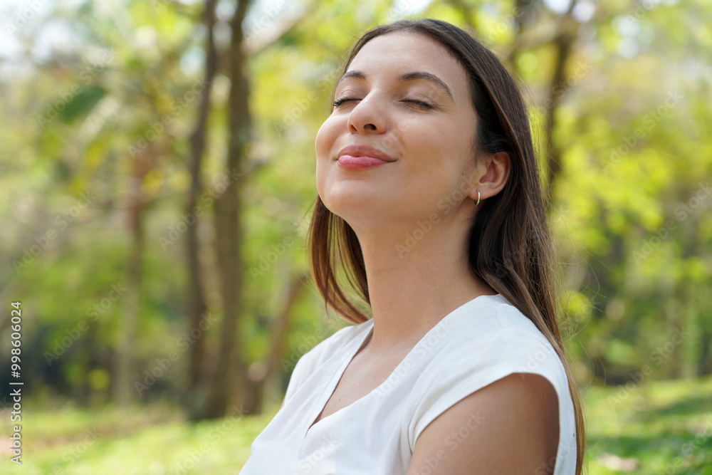 Beautiful relaxed young woman breathing fresh air in a city park Beautiful relaxed young woman breathing fresh air in a city park