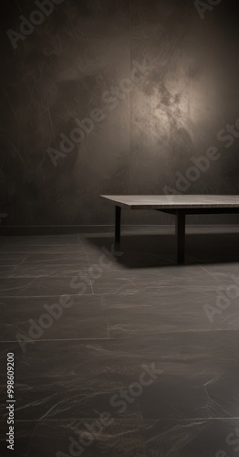 A minimalist black and white photograph rectangular table with a dark surface, set against a textured wall with a single light source