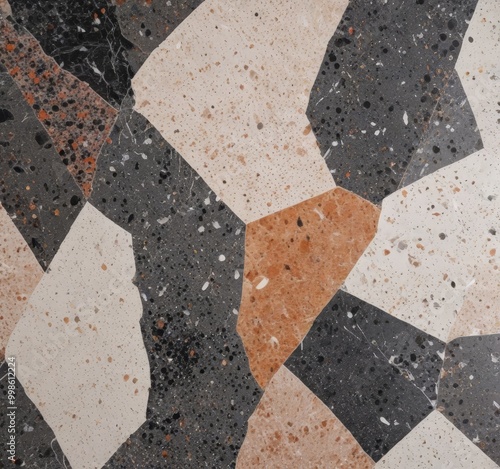 a close-up view mosaic tile pattern composed of irregularly shaped tiles in various shades of gray, black, and beige, with some areas featuring a speckled or