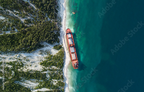 Aerial top down view of an abandoned bulk-carrier dry cargo ship washed ashore after a storm photo