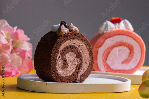 Delicious chocolate and strawberry Swiss roll cake, a type of rolled sponge cake filled with whipped cream, jam, icing, or any type of filling. photo