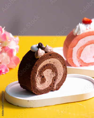 Fotografi Fluffy chocolate Swiss roll cake, a type of rolled sponge cake filled with whipped cream, jam, icing, or any type of filling