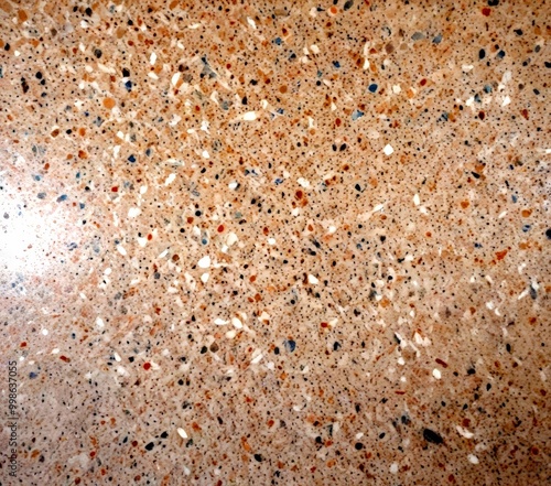 a close-up view terrazzo floor, which is a type of stone flooring The terrazzo has a speckled, speckled pattern with a variety of colors including shades of beige, gray,