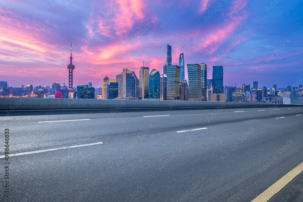 Naklejka premium Empty asphalt road and cityscape with skyline in modern city at sunset