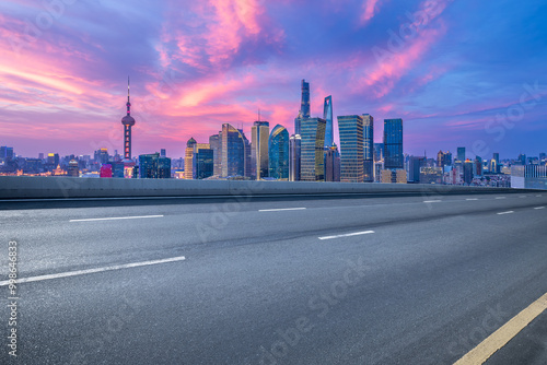 Empty asphalt road and cityscape with skyline in modern city at sunset