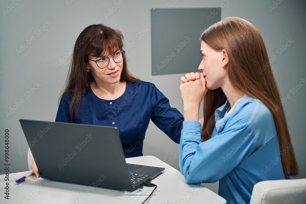Doctor and patient discussing results on a laptop screen Doctor and patient discussing results on a laptop screen