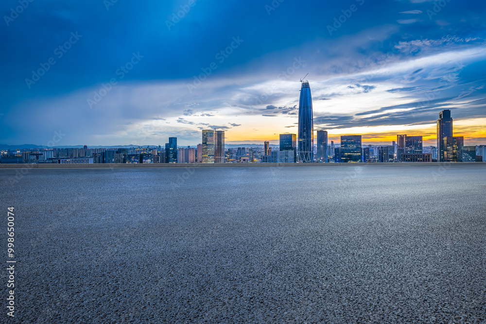 Empty asphalt road and cityscape with skyline in modern city at sunset Empty asphalt road and cityscape with skyline in modern city at sunset