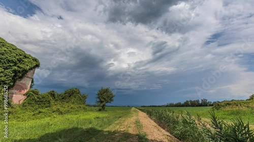 timelapse di media durata con inquadratura ampia su di una zona rurale di campagna, in pianura, nell'Italia nord orientale, di giorno, in estate, durante il passaggio di un temporale photo