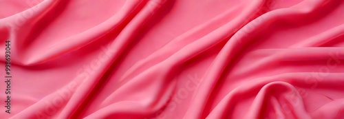 a close-up view soft, flowing pink fabric, with the fabric appearing to be made of silk or chiffon The fabric has a smooth, shiny texture and is crumpled, giving it a