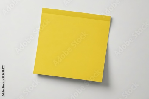 yellow post it note on a white surface with a shadow