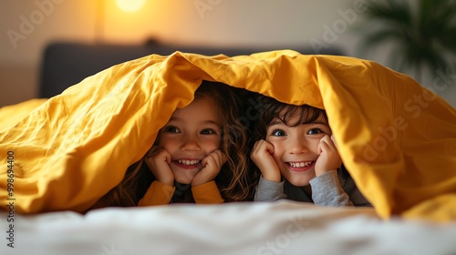Children peeking from under the blanket, cozy and warm moment