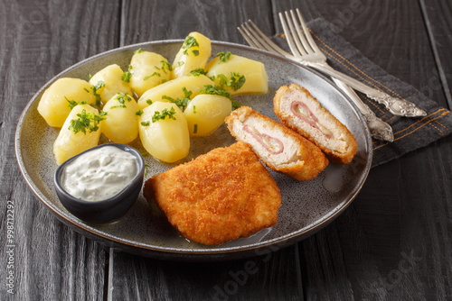 Canvas-taulu Tasty Chicken Cordon Bleu served with new potatoes and cream sauce closeup on the plate on the table