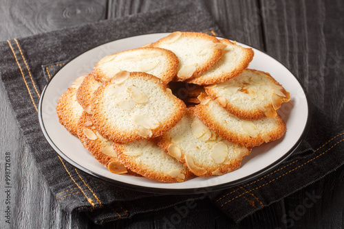 Obraz na płótnie Fresh homemade French almond tuile cookie closeup on the plate on the table. Horizontal w salonie