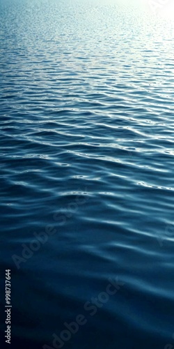 a serene body of water with rippling blue-green waves, captured from a low angle that emphasizes the depth and vastness of the water