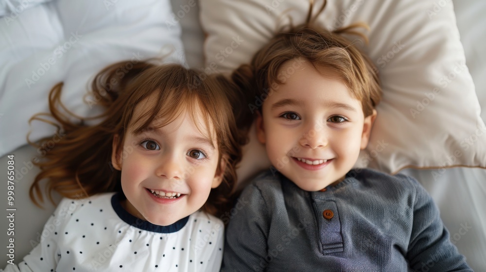 Happy Siblings Relaxing Together on a Bed Happy Siblings Relaxing Together on a Bed
