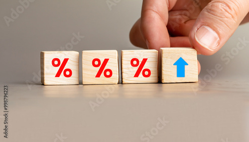 Hand Adjusting Wooden Blocks with Red Percentage Symbols and Upward Arrow Icon, Stock Image for Financial Concepts, Interest Rate Hikes, Business Growth, Economics, and Investment Trends.