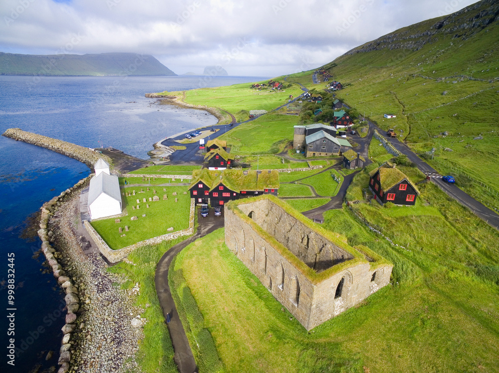 Naklejka premium Aerial view of historical Kirkjubøur village with ruins of the Magnus Cathedral and Saint Olav's Church, Faroe Island