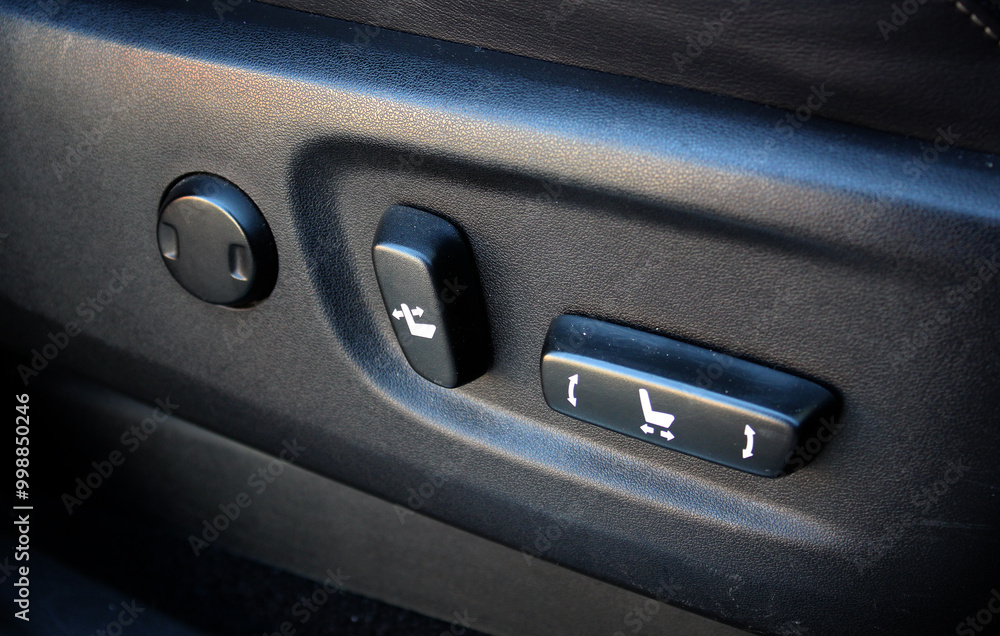 Electric driver seat buttons. Button for adjusting the car electric seat. Lux car leather driver seat. Black leather car interior. Premium car interior with buttons for adjusting seat position. Electric driver seat buttons. Button for adjusting the car electric seat. Lux car leather driver seat. Black leather car interior. Premium car interior with buttons for adjusting seat position.
