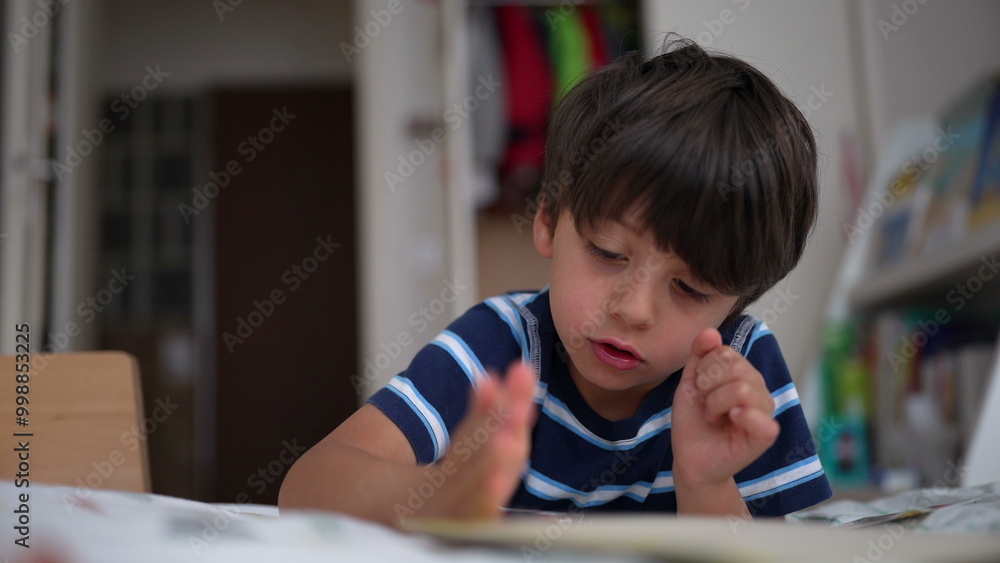 Young boy intently focusing on a small toy or puzzle while sitting on his bed in a child’s room, demonstrating concentration and engagement Young boy intently focusing on a small toy or puzzle while sitting on his bed in a child’s room, demonstrating concentration and engagement