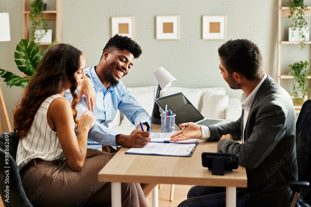 Young couple signing a contract with an agent in the office Young couple signing a contract with an agent in the office