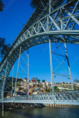 Close-up of the Dom Luís I Bridge's intricate metal structure, with a clear blue sky