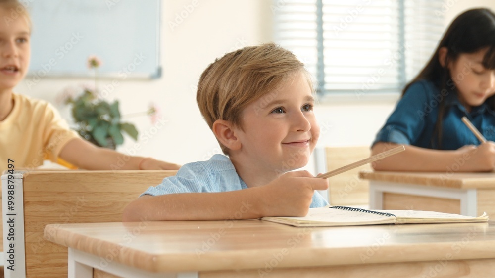 Caucasian boy raising hand for asking and answering teacher surrounded by diverse children studying at classroom. Happy student working together, voting, volunteering, calling instructor. Pedagogy. Caucasian boy raising hand for asking and answering teacher surrounded by diverse children studying at classroom. Happy student working together, voting, volunteering, calling instructor. Pedagogy.