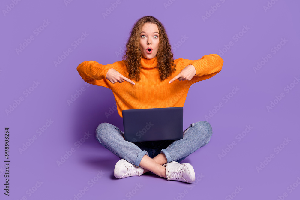 Full size photo of nice young girl point fingers laptop wear pullover isolated on violet color background Full size photo of nice young girl point fingers laptop wear pullover isolated on violet color background