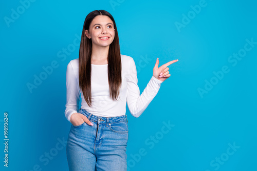 Photo portrait of pretty teen girl point look empty space wear trendy white outfit isolated on blue color background