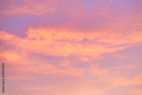 A beautiful sky tinted by the sun leaving vibrant shades of gold, pink, blue and multicolored. Clouds in the twilight evening and morning sky. Cloudy sky background in the evening, and during the day.