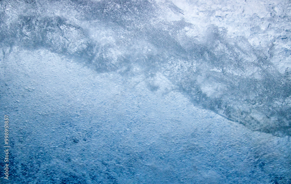 Obraz premium Struktur von sprudelndem Wasser hinter einer Glasscheibe