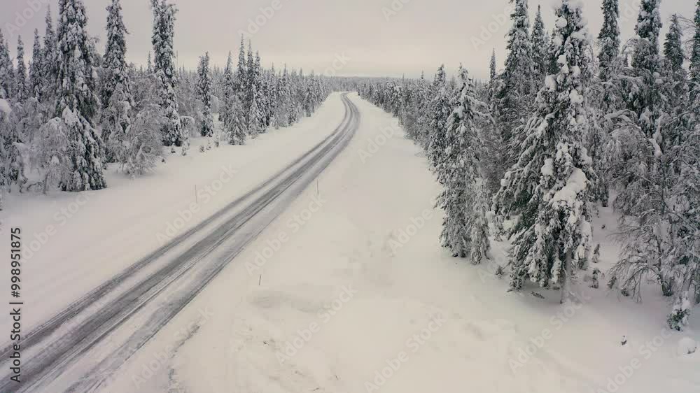 A snowy highway stretches through a quiet forest, flanked by tall trees blanketed in snow. The landscape creates a peaceful winter atmosphere. A snowy highway stretches through a quiet forest, flanked by tall trees blanketed in snow. The landscape creates a peaceful winter atmosphere.