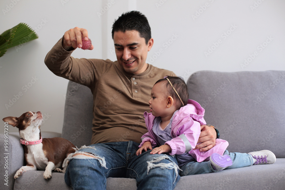 Young father plays with his dog and his baby Young father plays with his dog and his baby