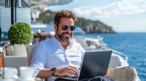 A relaxed individual enjoys the scenic beauty of the open sea while leisurely working on a laptop aboard a luxurious yacht, embodying freedom and peace.