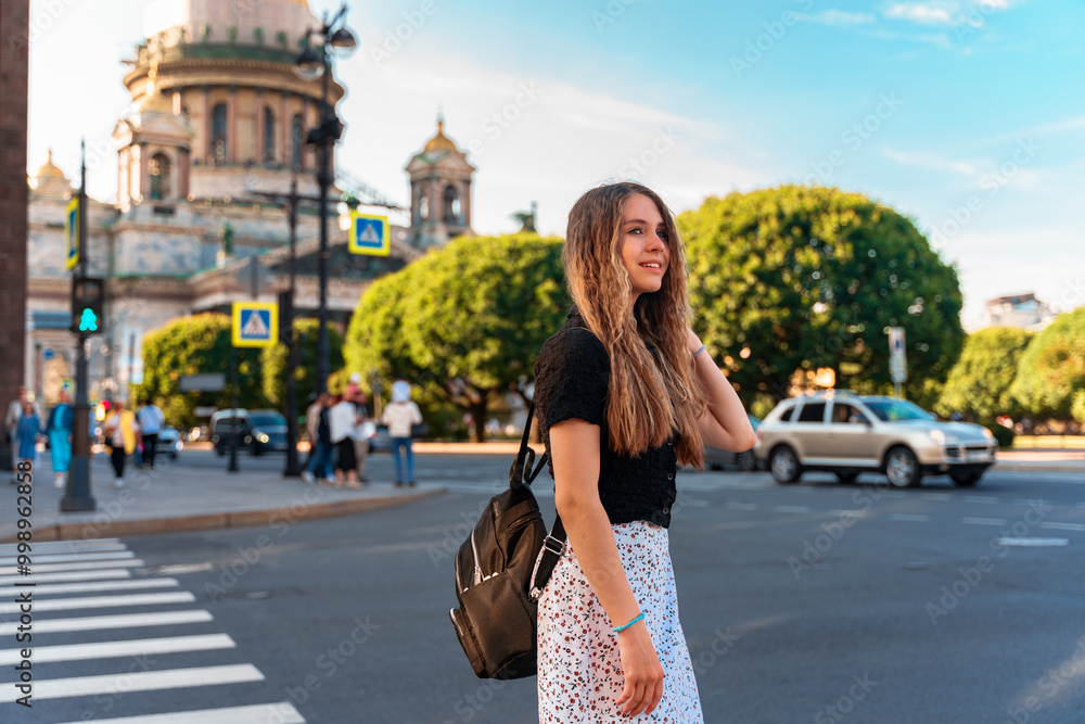 Young girl with long hair standing near St. Isaac's Cathedral in St. Petersburg. The concept of the tourist season, an active pastime. Young girl with long hair standing near St. Isaac's Cathedral in St. Petersburg. The concept of the tourist season, an active pastime.