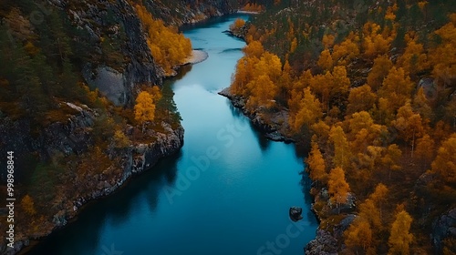 The deep blue water of the lake is surrounded by high cliffs and orange trees, with autumn colors