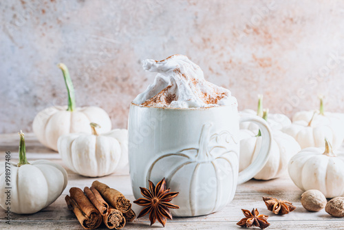 A cozy pumpkin spice latte in a white mug on a rustic beige background. photo