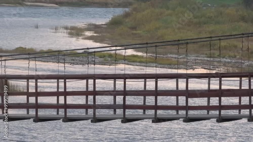 Suspension bridge over the taiga river. Extreme. 