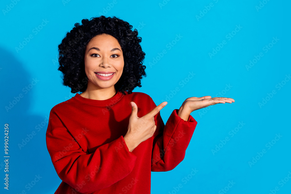 Photo portrait of lovely young lady point hold empty space dressed stylish red garment isolated on blue color background Photo portrait of lovely young lady point hold empty space dressed stylish red garment isolated on blue color background