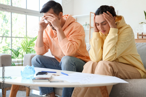 Worried young couple in deb...