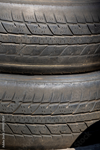 Obraz na płótnie Worn and damaged tread of old tires lying in a landfill. Decreased road safety and environmental pollution from rubber waste w salonie