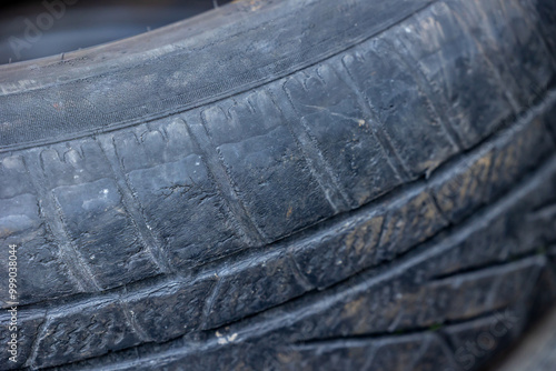 Obraz na płótnie Worn and damaged tread of old tires lying in a landfill. Decreased road safety and environmental pollution from rubber waste w salonie
