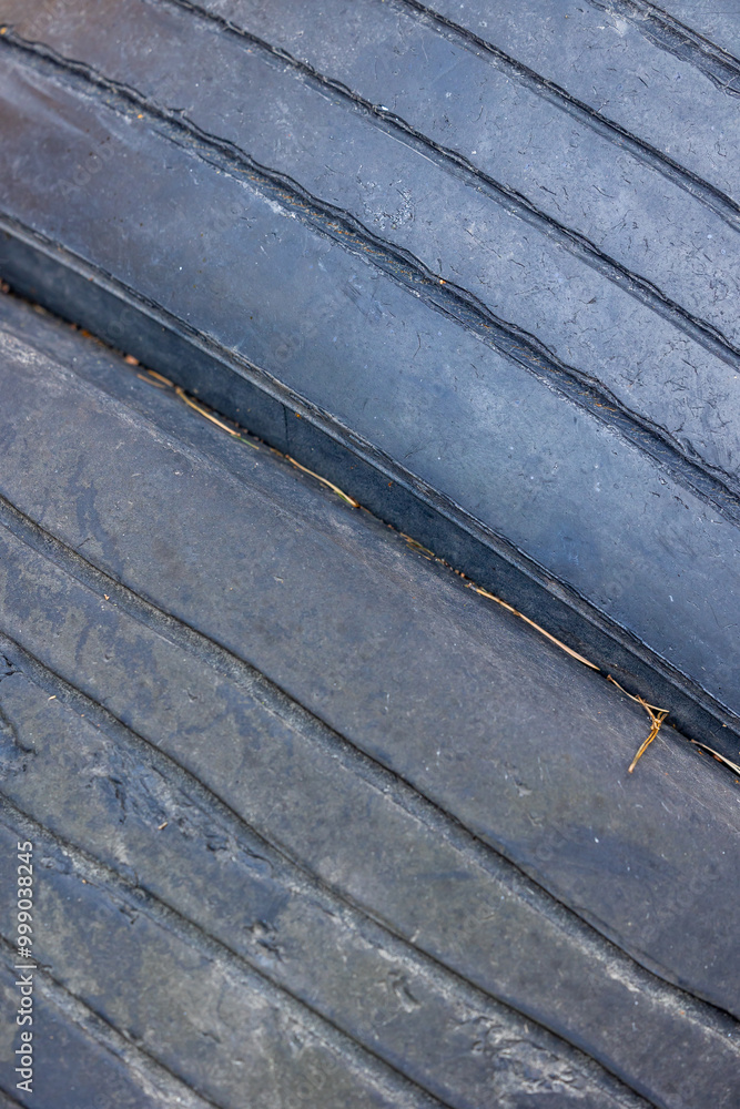 Worn and damaged tread of old tires lying in a landfill. Decreased road safety and environmental pollution from rubber waste