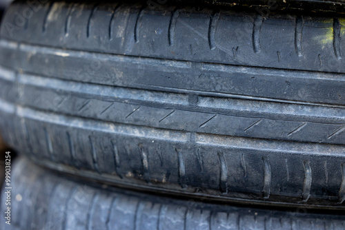 Worn and damaged tread of old tires lying in a landfill. Decreased road safety and environmental pollution from rubber waste